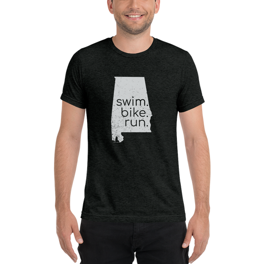 A person wearing a black short sleeve shirt with 'swim, bike, run' text and a silhouette of Alabama.