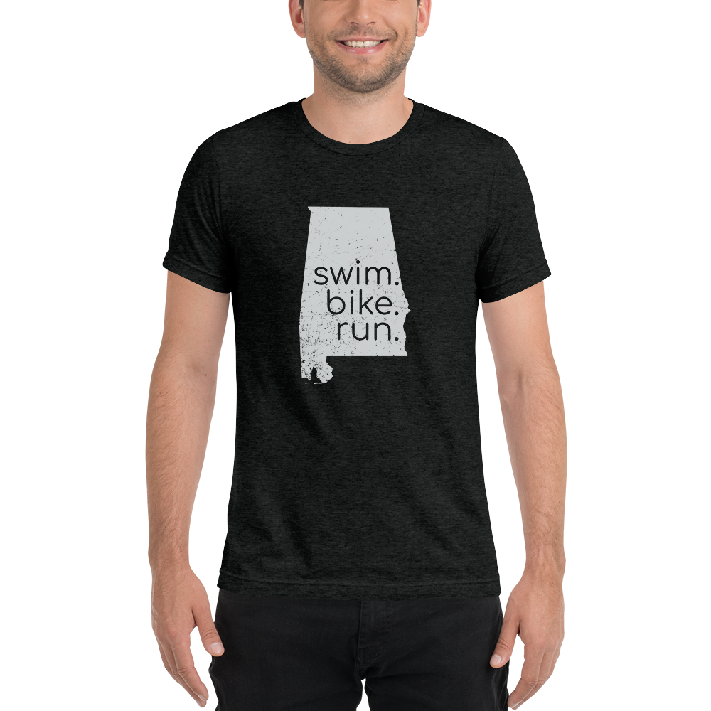 A person wearing a black short sleeve shirt with 'swim, bike, run' text and a silhouette of Alabama.
